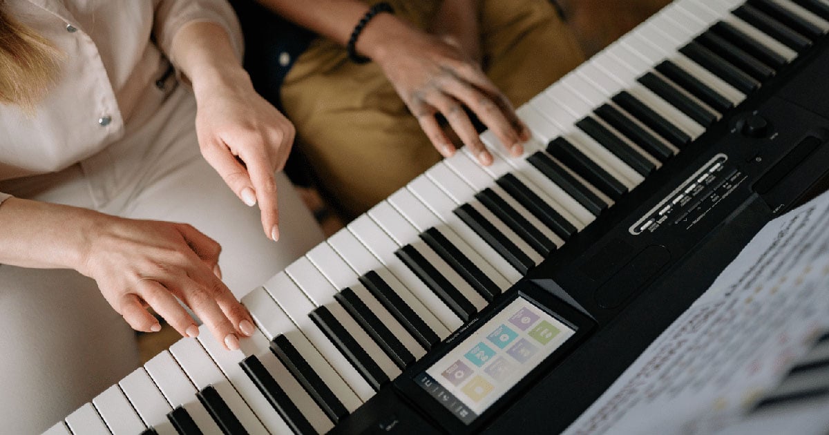 Mother teaching son to play piano